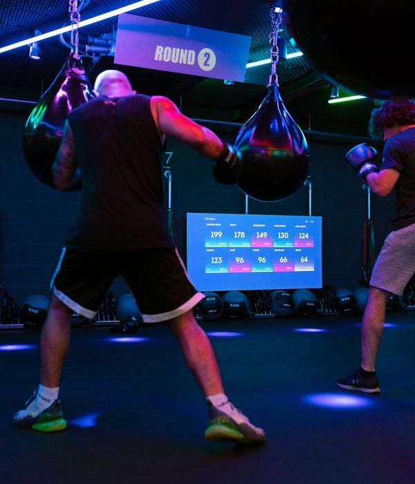 Man performing a dynamic endurance exercise with cyan light accents.